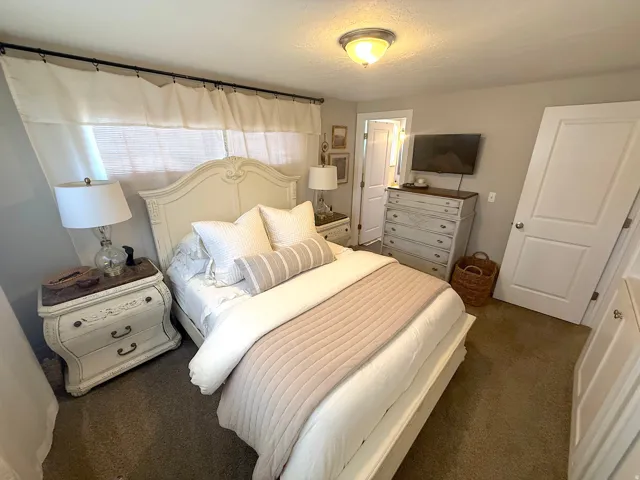 Neutral wall tones complement the ceiling-mounted light fixture and soft window treatments