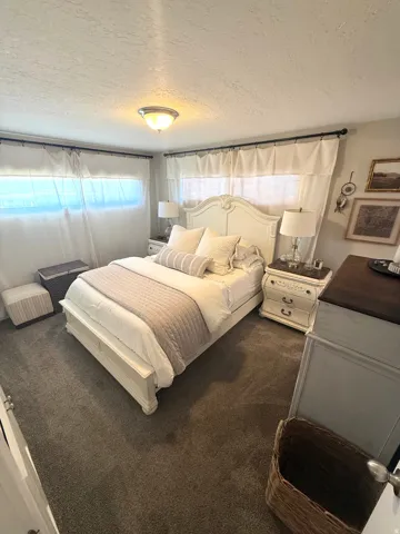 Wall-to-wall carpeting with multiple windows and a ceiling-mounted light fixture