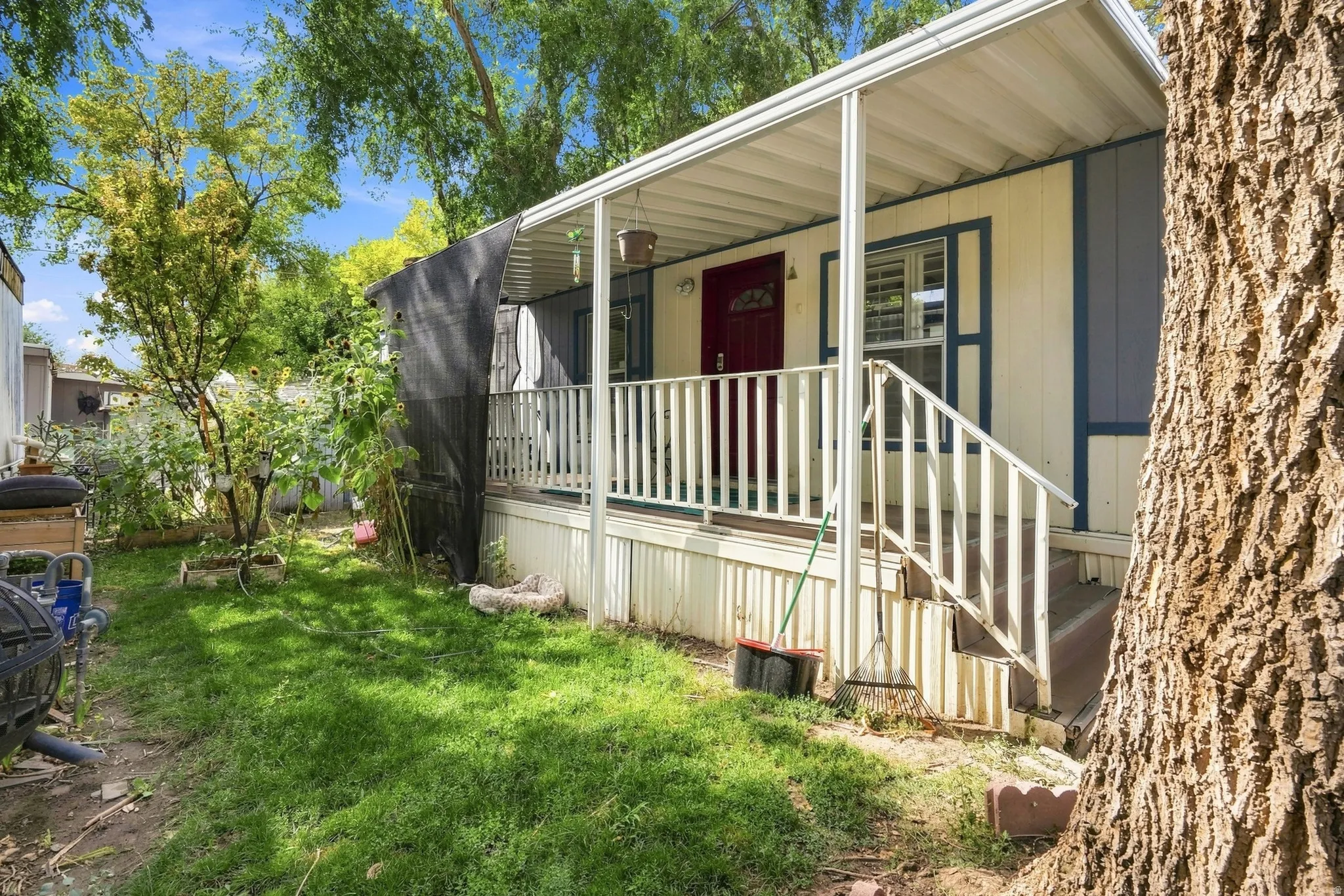 Covered porch entry with white railing and steps