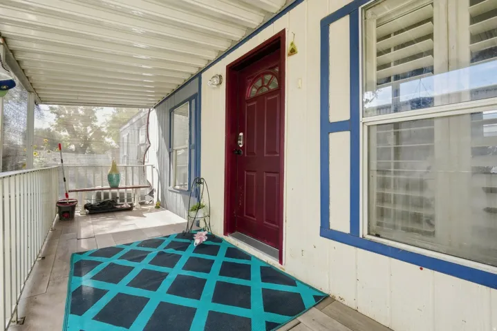 Covered porch with wood-look flooring and white railing