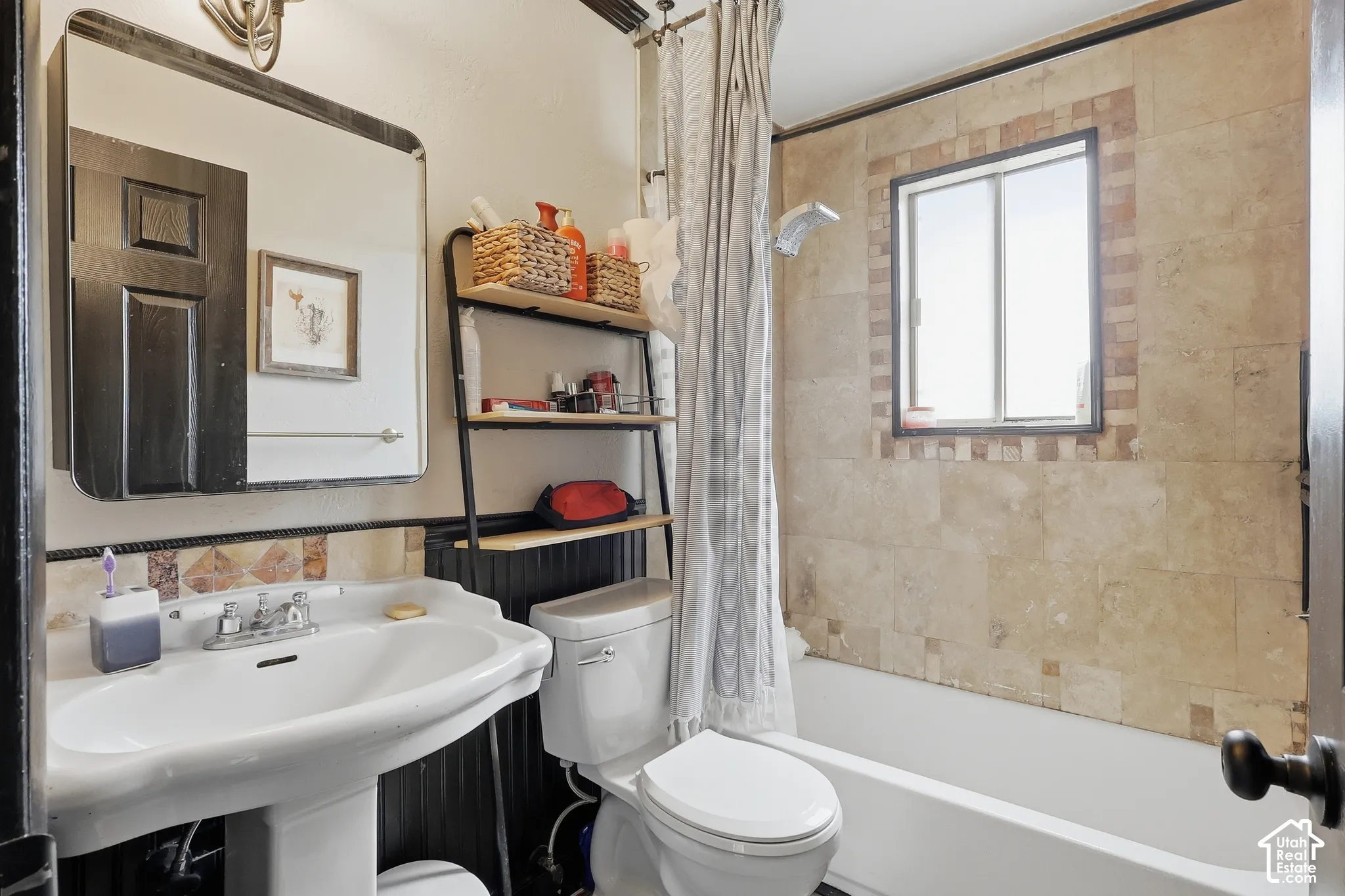 Pedestal sink with chrome faucet, framed mirror, and tiled backsplash