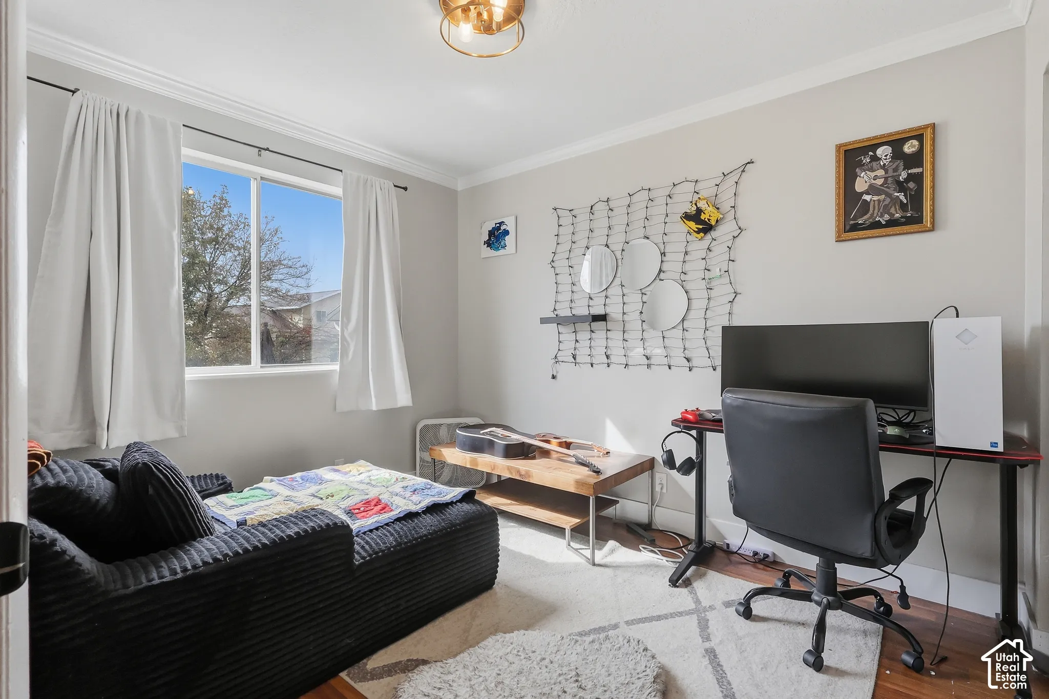 Hardwood-style flooring throughout, crown molding, and a prominent window with a white frame