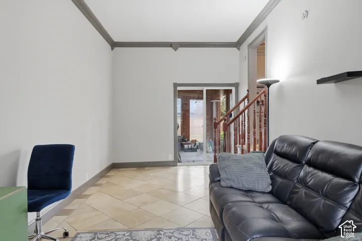 Tiled flooring with a diagonal pattern, sliding glass door, crown molding, and built-in shelving