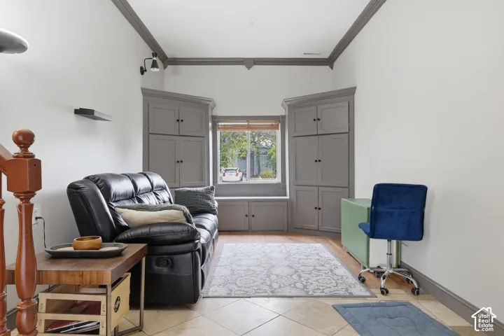 Built-in corner cabinetry, window with a built-in bench, wood-finish flooring, and crown molding
