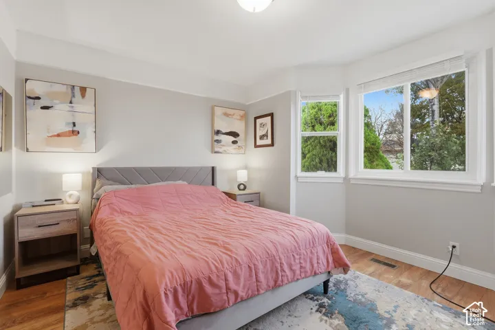 Wood-finish flooring, multiple windows, recessed lighting, and light grey wall tones