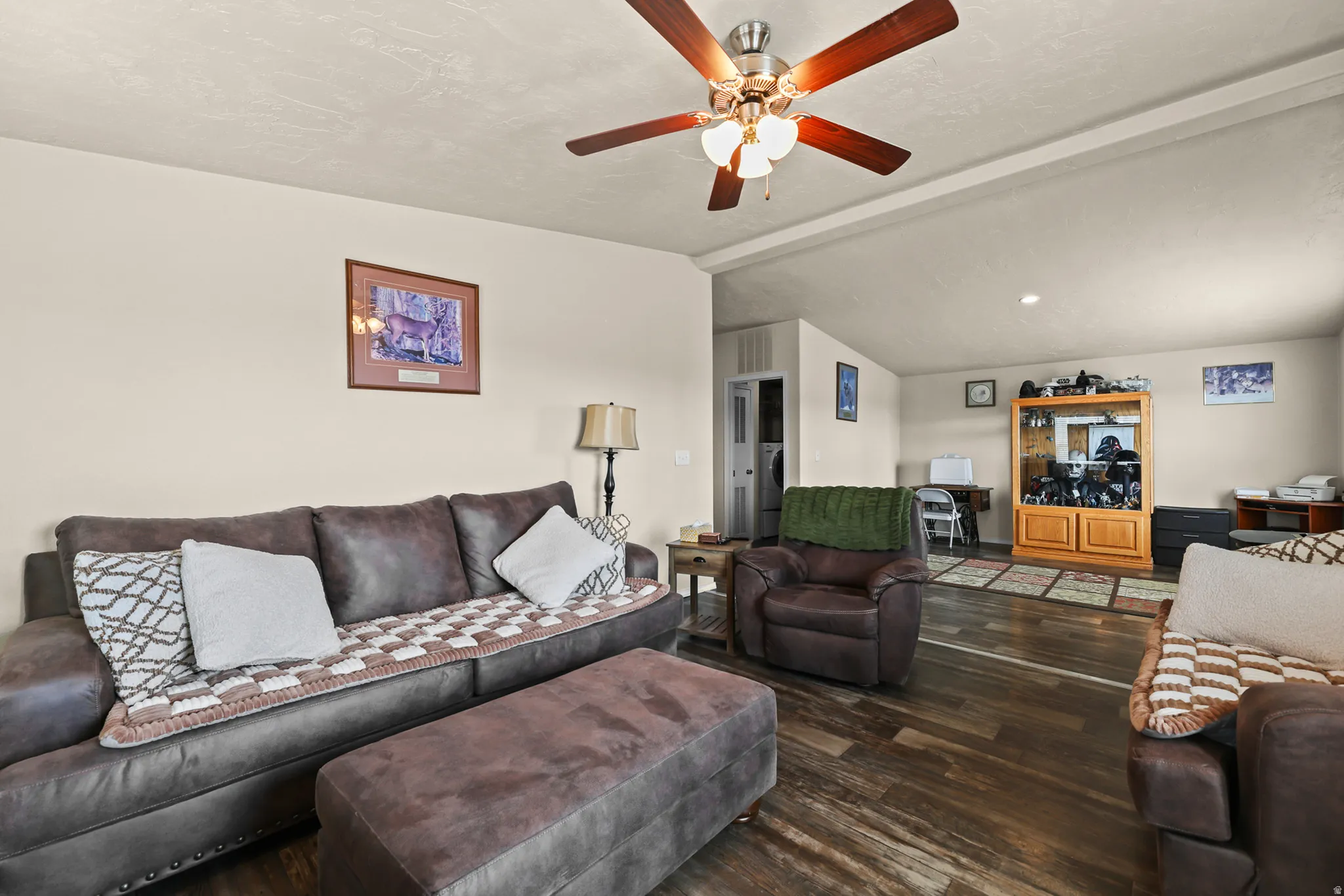 Wood-finish flooring throughout the main area, complemented by a ceiling fan with integrated lighting
