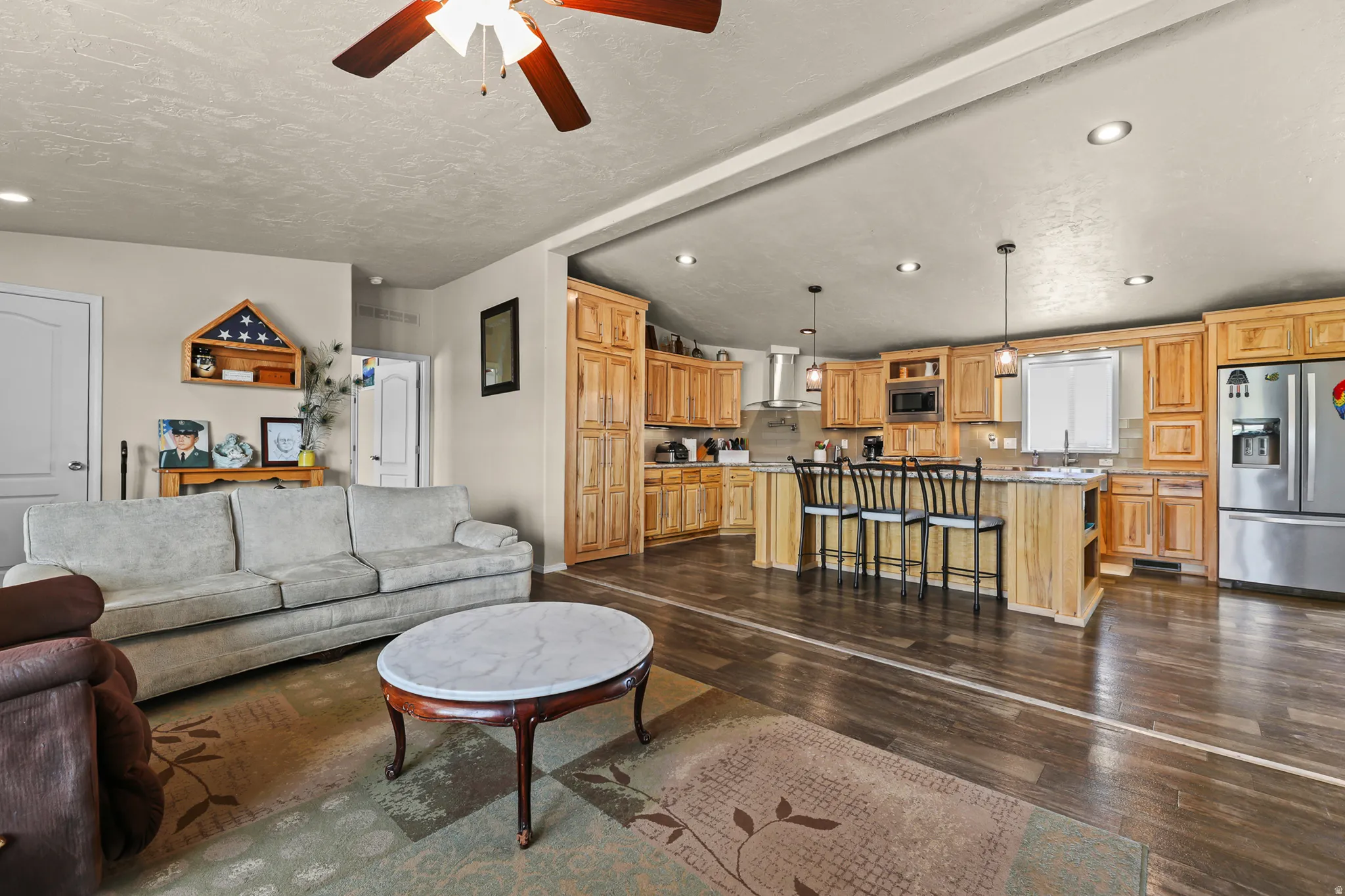 Wood-finish flooring throughout, complemented by recessed lighting and a ceiling fan