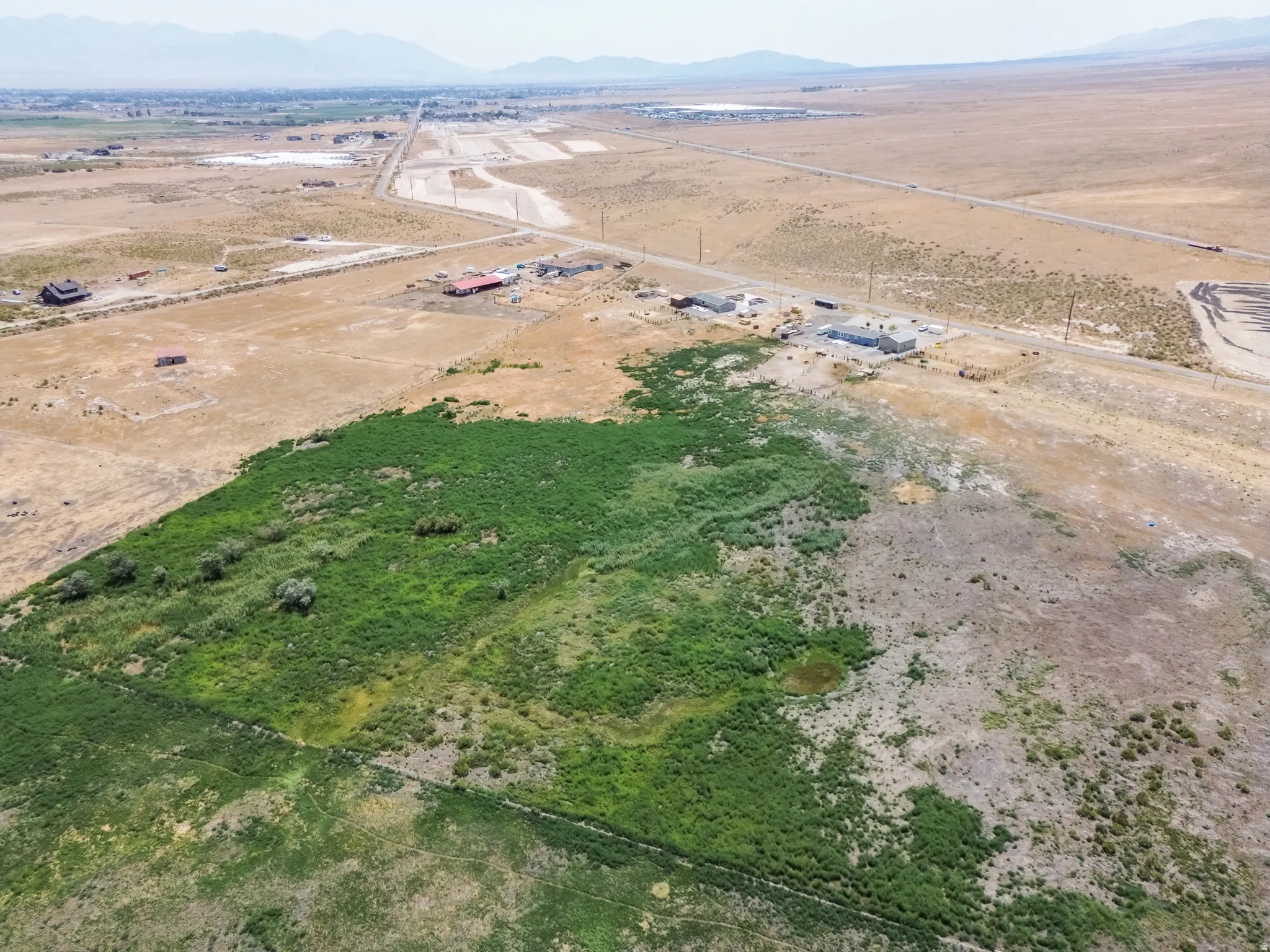 Expansive undeveloped land featuring varied terrain and natural vegetation, including areas of dense green growth