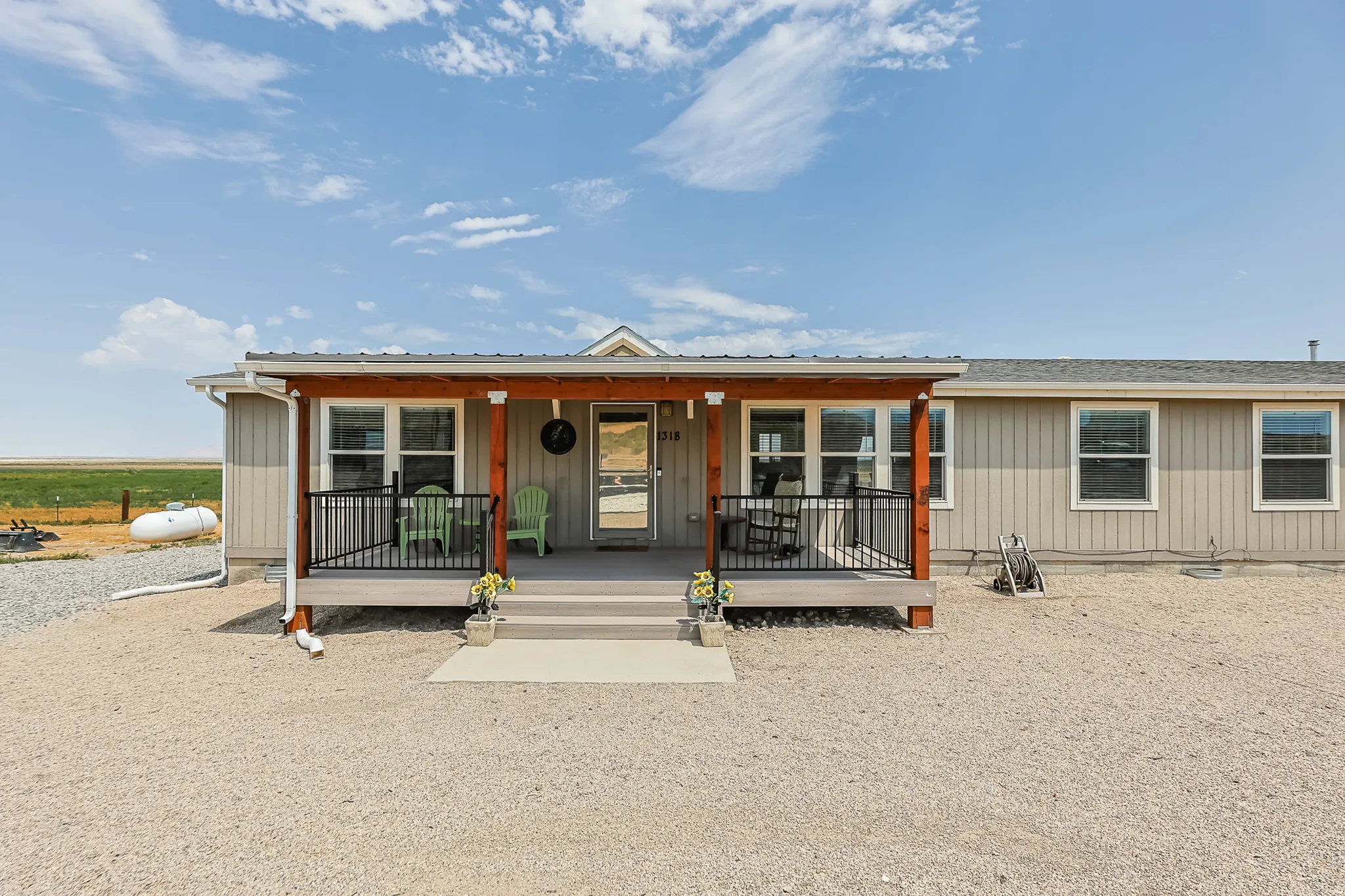 Front porch with a metal roof, wood columns, and black railings
