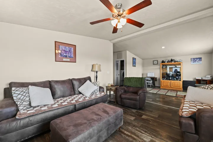 Wood-finish flooring throughout the main area, complemented by a ceiling fan with integrated lighting
