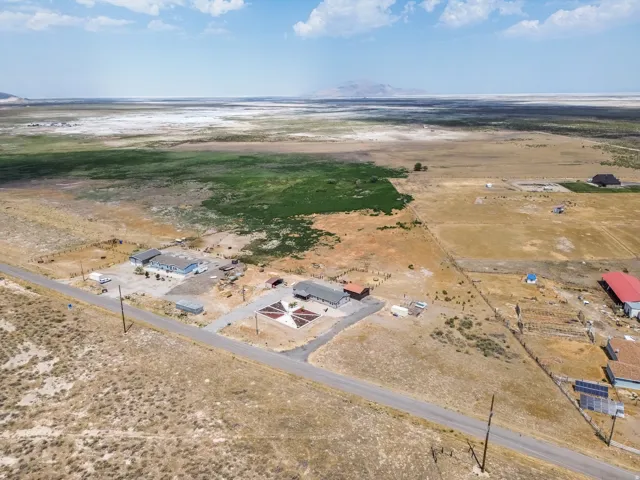 Expansive property featuring multiple structures, a paved road frontage, and a large open land area