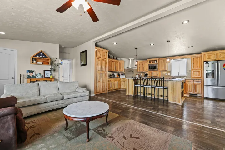 Wood-finish flooring throughout, complemented by recessed lighting and a ceiling fan