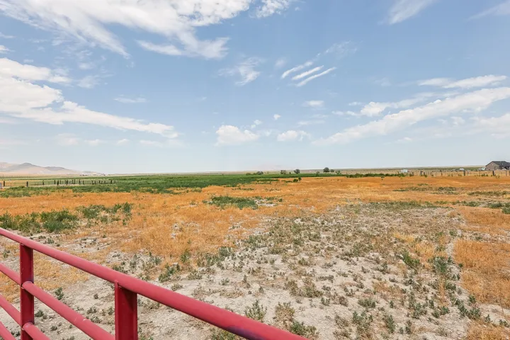 Expansive rural landscape featuring a red metal fence