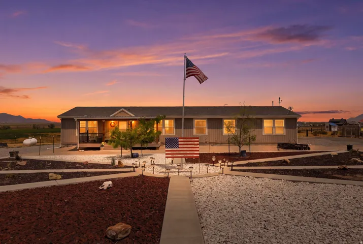 Single-story residence featuring a covered front porch, multiple windows, and a paved walkway leading to the entrance
