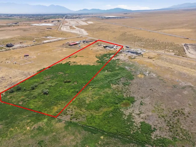 Expansive lot featuring varied terrain, a small pond, and distant mountain scenery