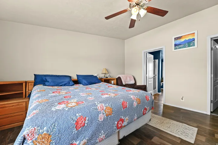 Vaulted ceiling with a ceiling fan, wood-finish flooring, and recessed doorway