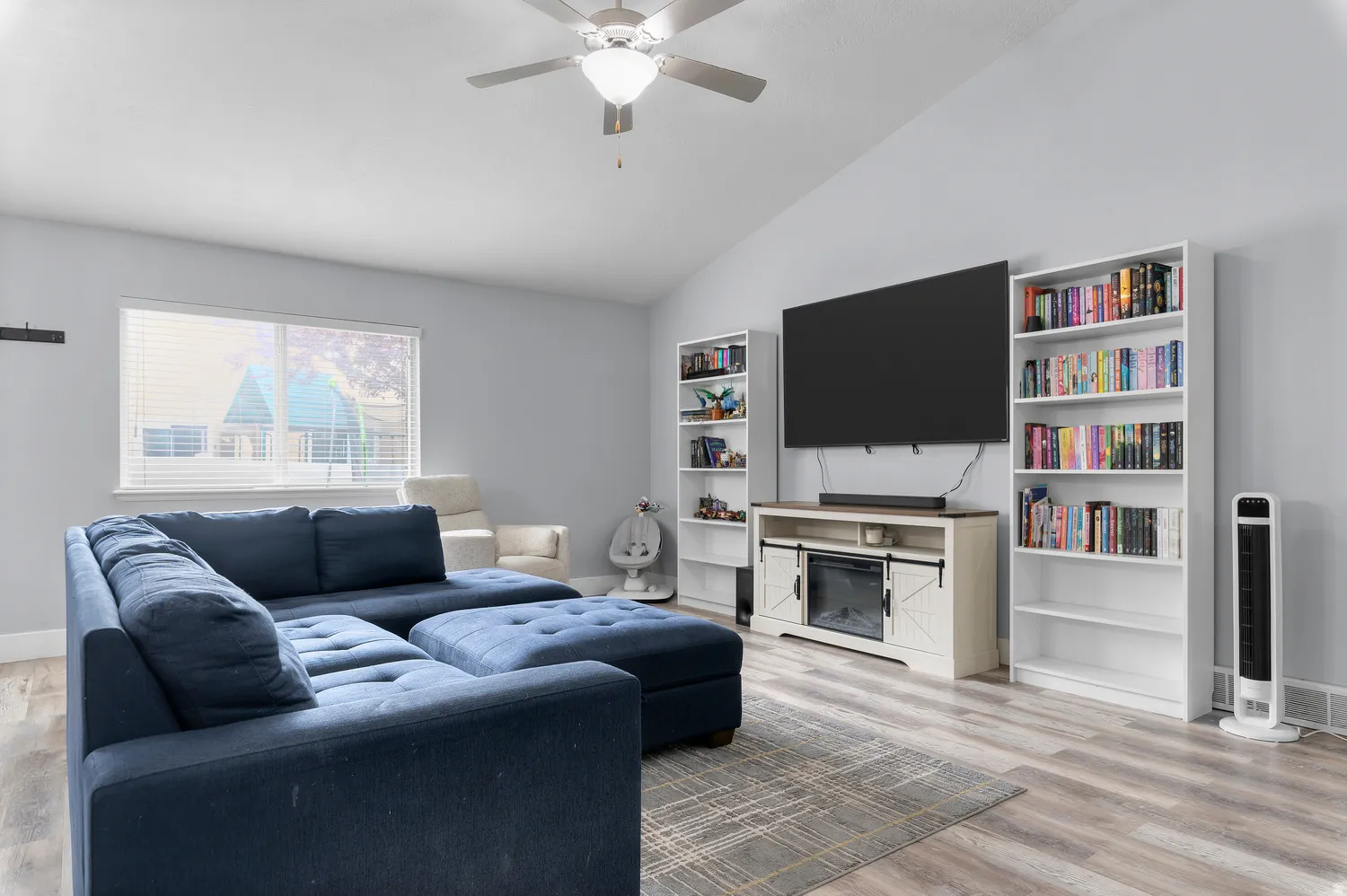 Vaulted ceilings with a ceiling fan, wood-finish flooring, and white window blinds