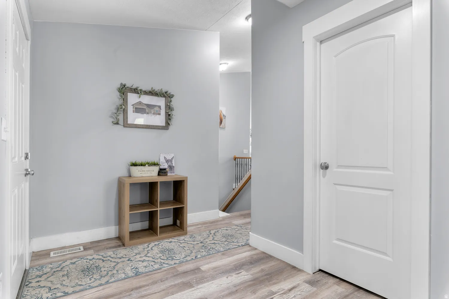 Light gray wall paint, white trim, wood-finish flooring, and white interior doors