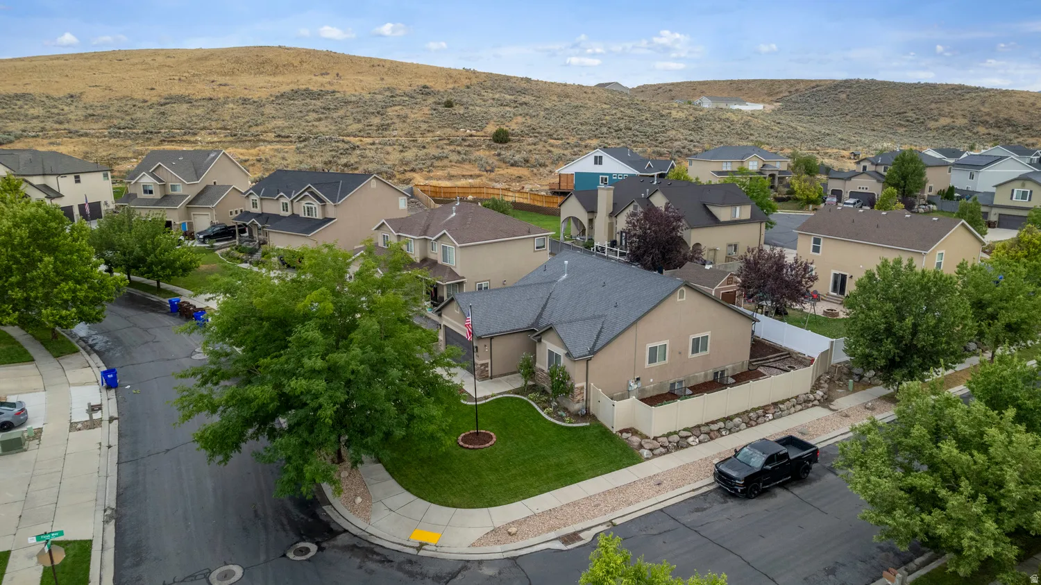 Single-story residence featuring a tan stucco exterior, dark shingle roof, and an attached garage