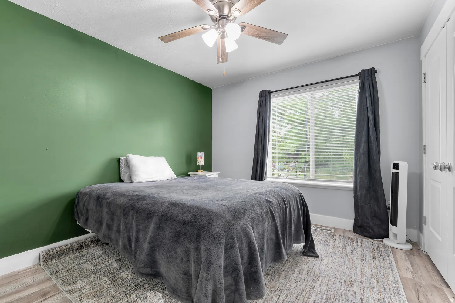 Recessed lighting, wood-finish flooring, ceiling fan, large window, and white trim