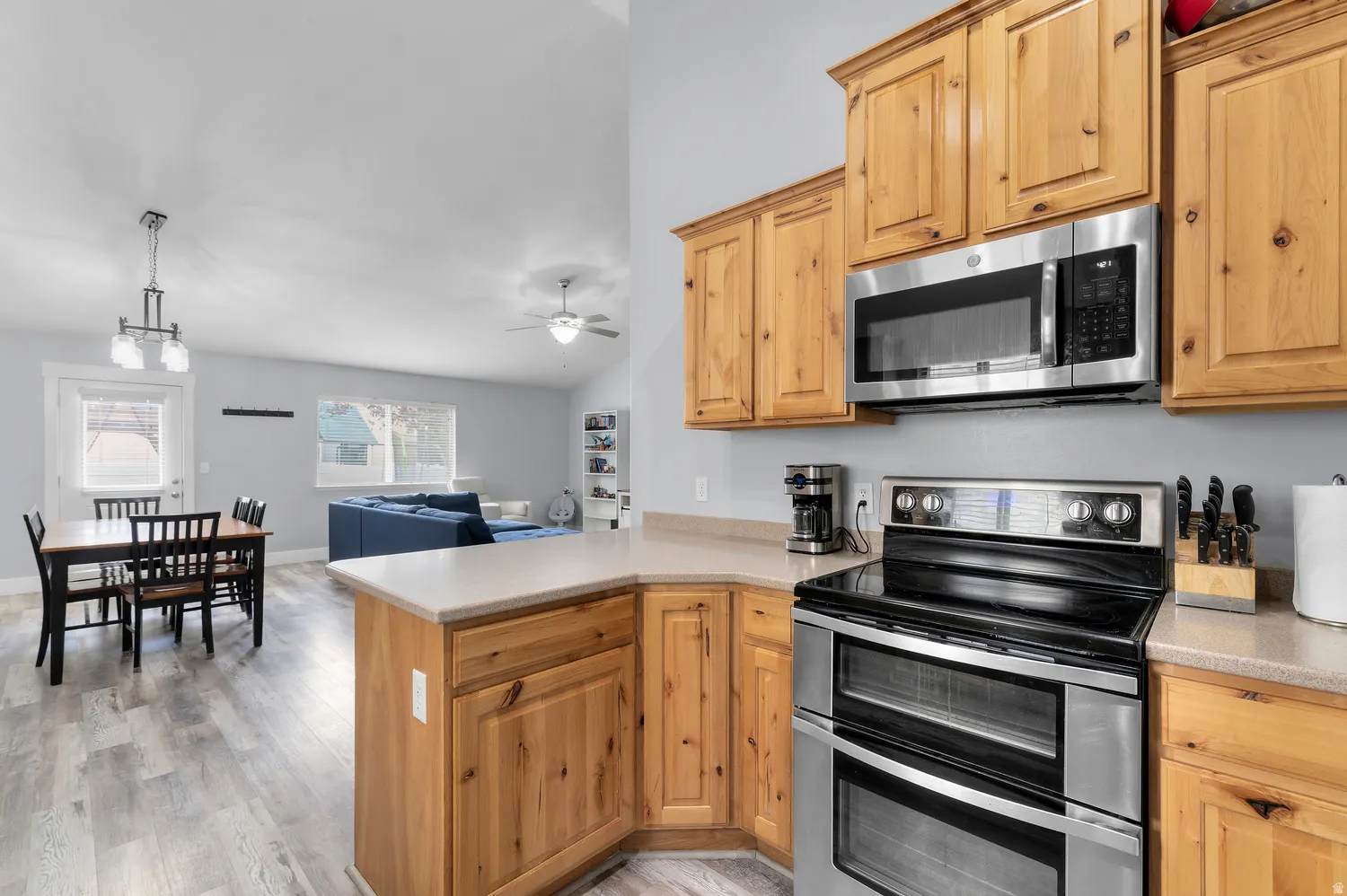 Natural wood-finish cabinetry, stainless steel appliances, durable laminate countertops, high ceilings, and wood-finish flooring