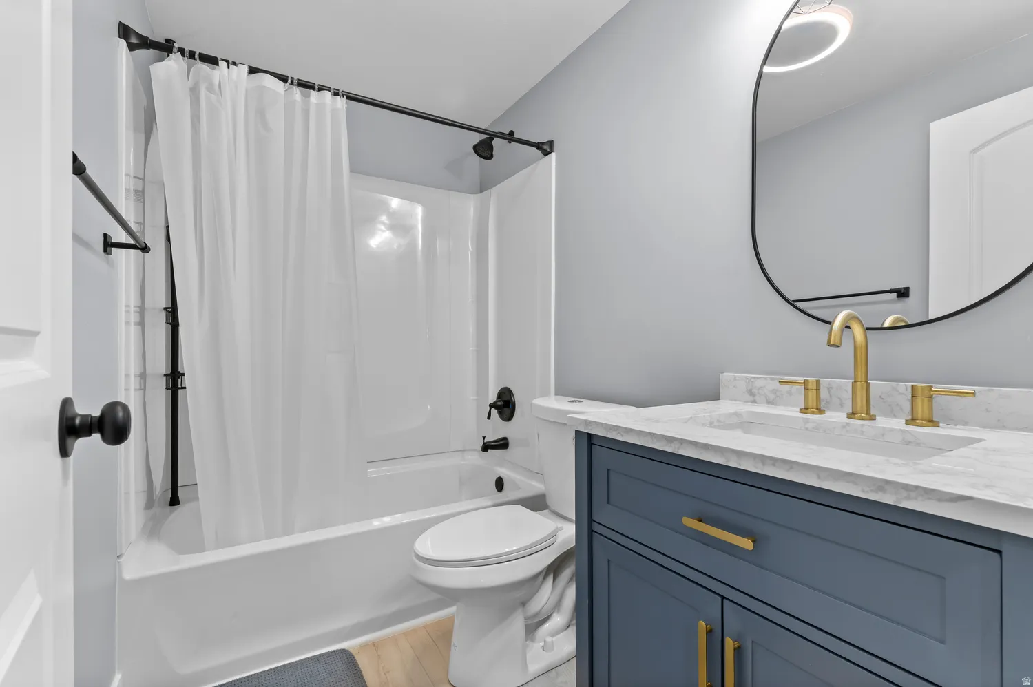 White bathtub and shower combination with matte black fixtures