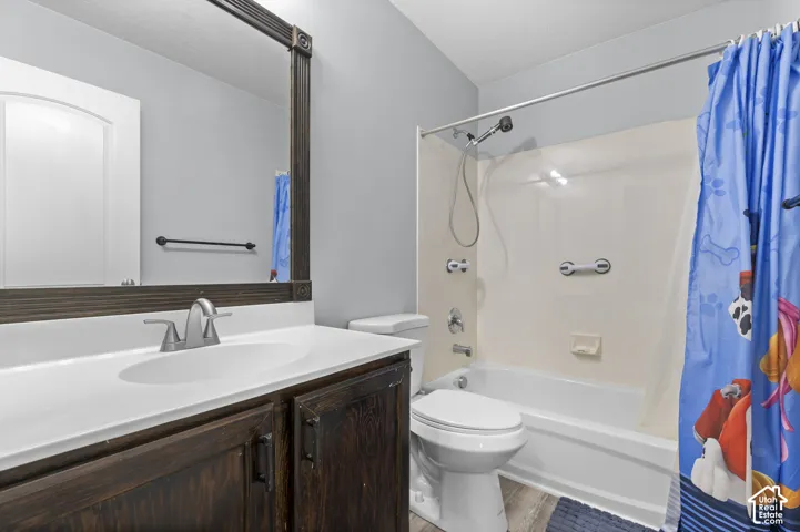 Bathroom featuring a dark wood-finish vanity with a white countertop and undermount sink, brushed nickel faucet, and a large mirror with an ornate frame