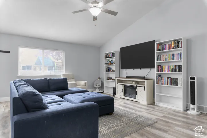 Vaulted ceilings with a ceiling fan, wood-finish flooring, and white window blinds