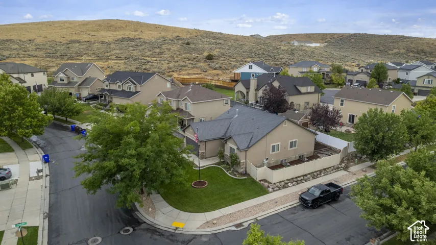 Single-story residence featuring a tan stucco exterior, dark shingle roof, and an attached garage