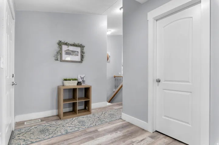 Light gray wall paint, white trim, wood-finish flooring, and white interior doors