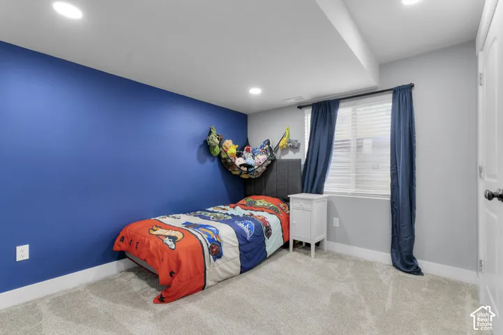Recessed ceiling lighting illuminates a room with a window featuring horizontal blinds