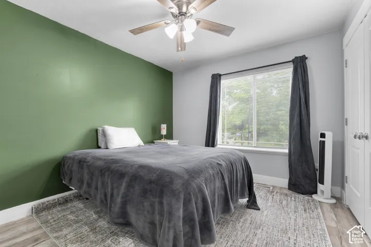 Recessed lighting, wood-finish flooring, ceiling fan, large window, and white trim