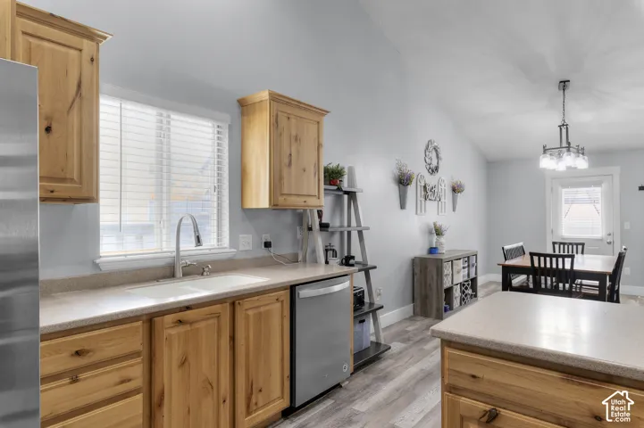Kitchen featuring wood cabinetry, stainless steel dishwasher, and a double basin sink