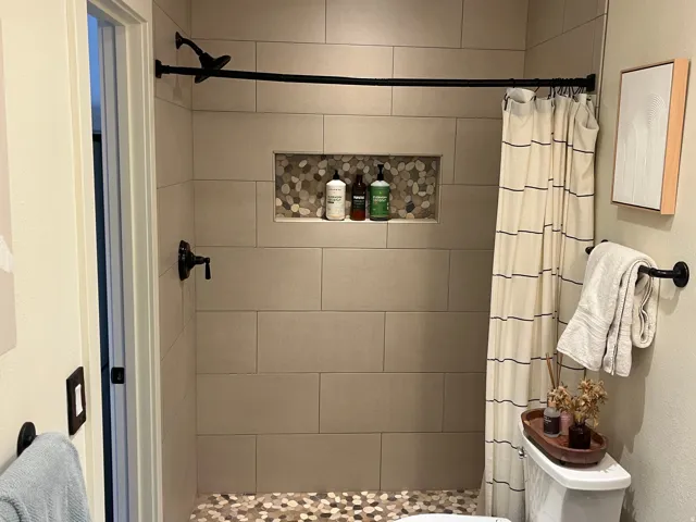 Walk in Shower with large format rectangular tile, pebble flooring,