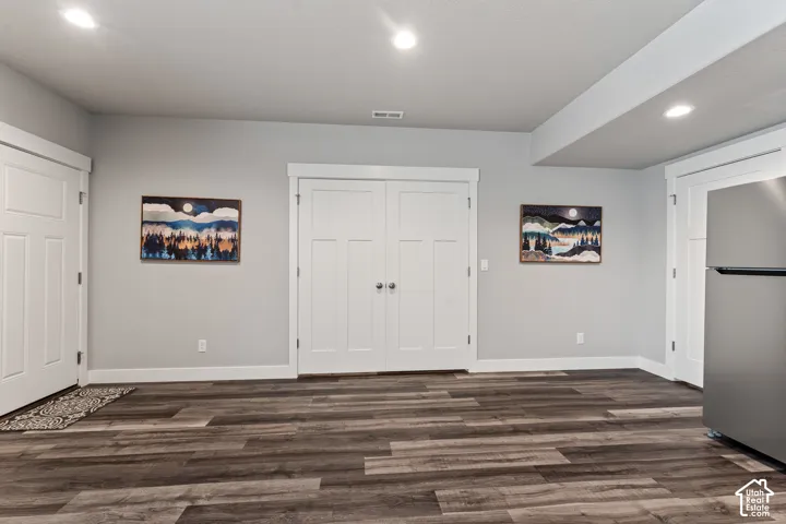 Wood-finish flooring, recessed lighting, light gray wall tones, and white trim