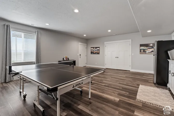 Recessed lighting, wood-finish flooring, white trim, and a window with blinds