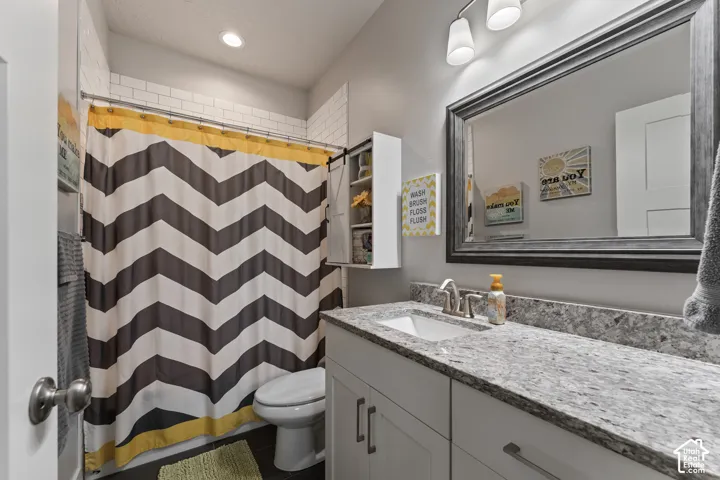 Single vanity with a light-toned countertop, integrated sink, and brushed nickel faucet