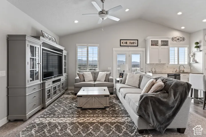 Vaulted ceilings with recessed lighting, ceiling fan, and double patio doors with transoms