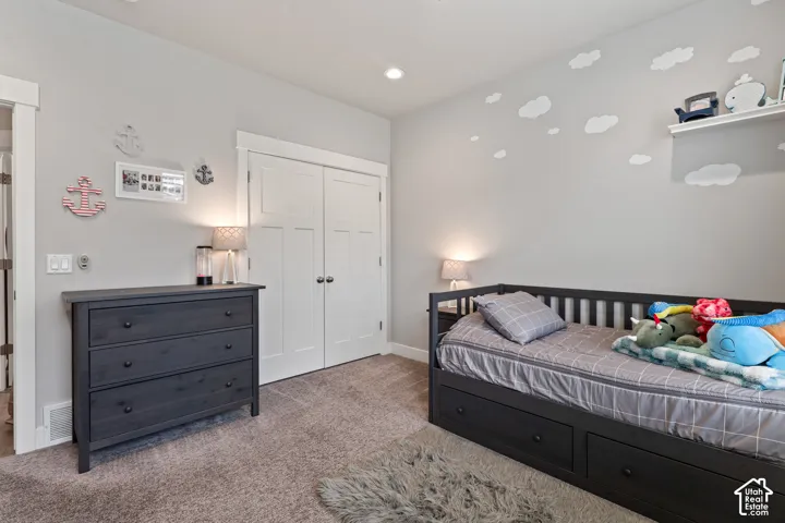 Recessed lighting, light gray wall color, white trim, white paneled double-door closet, and carpeted flooring