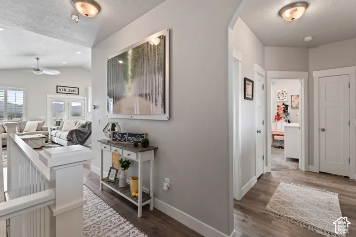 Neutral wall paint throughout, wood-finish flooring, white trim details, recessed lighting, and a ceiling fan