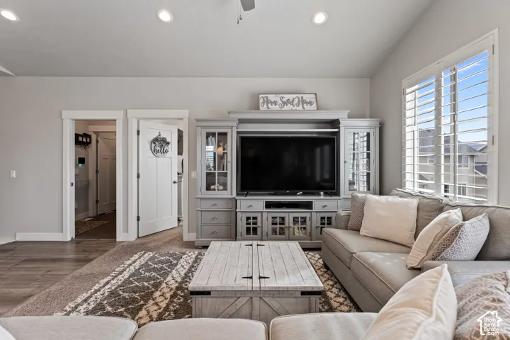 Recessed lighting, wood-finish flooring, white plantation shutters, built-in media center, and white trim