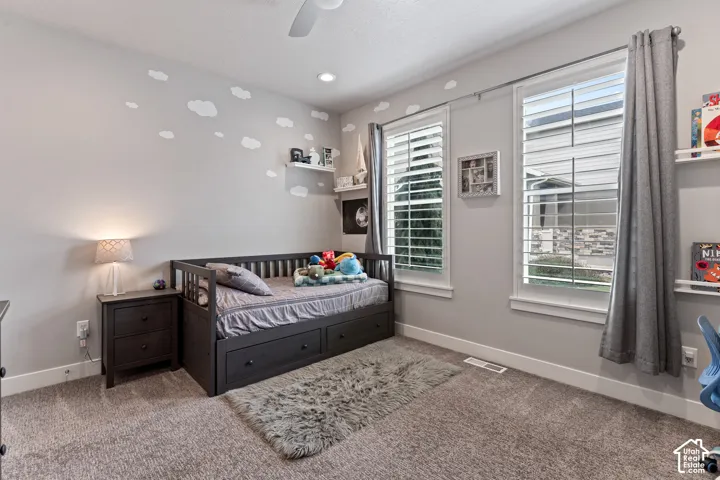 Neutral wall color, recessed lighting, ceiling fan, carpeted flooring, and two windows with plantation shutters