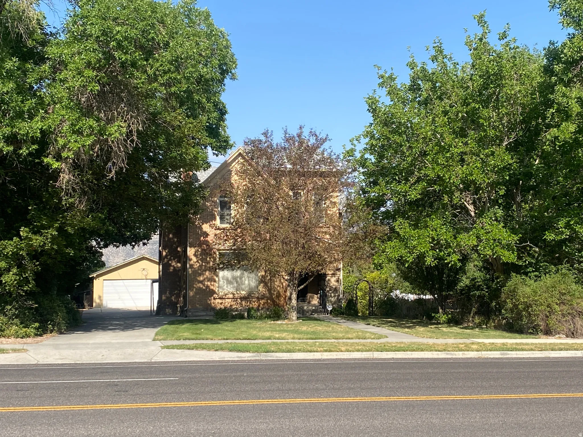 Two-story exterior with a pitched roof, brick facade, and mature landscaping