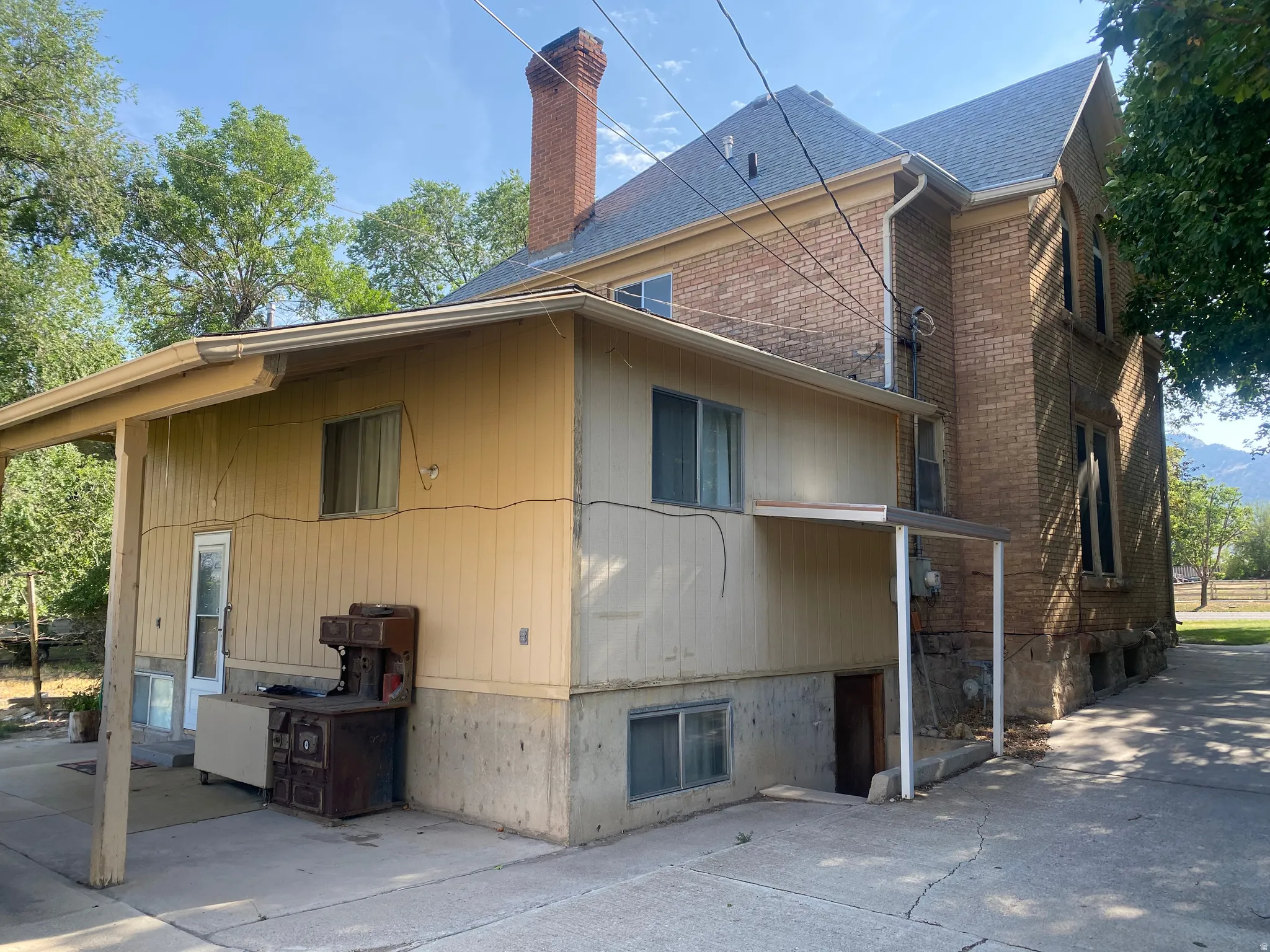 Brick exterior with a prominent brick chimney, multi-pane windows, and a covered entry