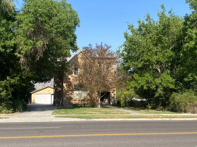 Two-story exterior with a pitched roof, brick facade, and mature landscaping