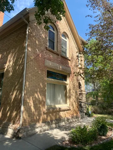 Brick exterior with arched windows, stone detailing, and a decorative stained-glass transom
