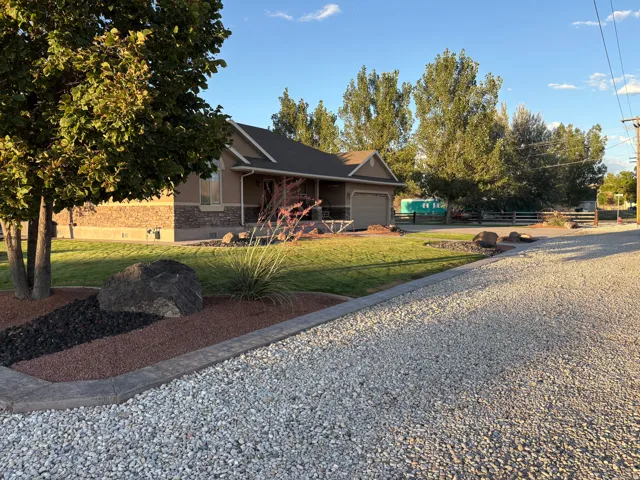 Exterior featuring a stone and stucco facade, attached garage, and covered porch