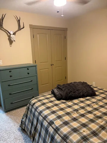Neutral wall paint, carpeted flooring, and a ceiling fan with integrated lighting