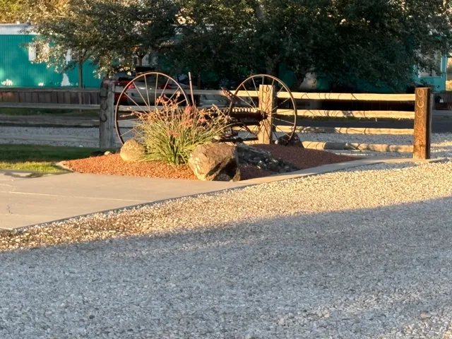 Gravel driveway leading to a concrete path with a decorative rock garden