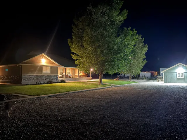 Ranch-style residence featuring a covered porch, stone-accented facade, and manicured lawn